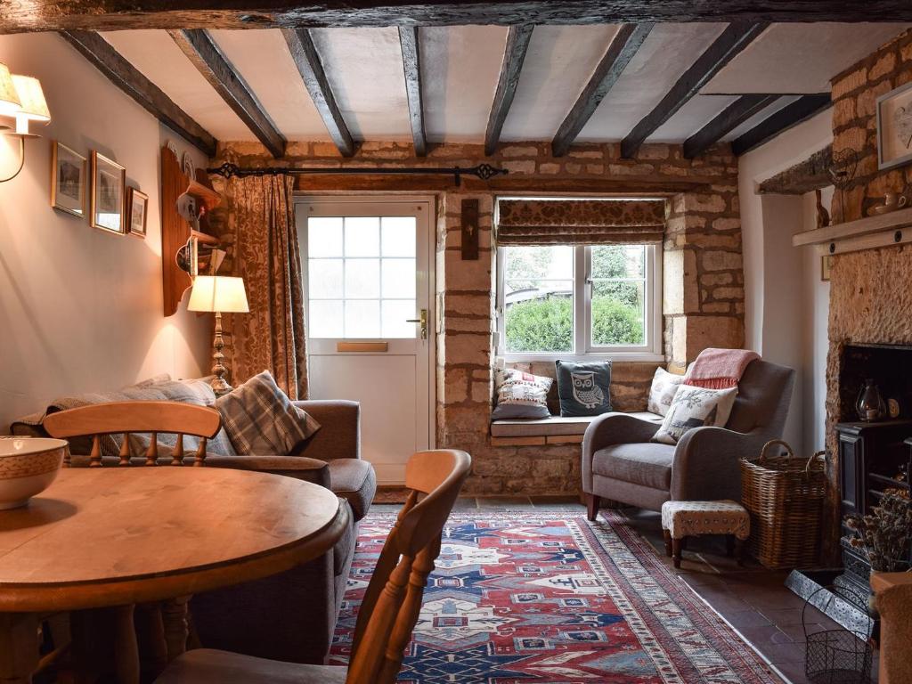 a living room with a table and chairs at Cosy Cottage in Bourton on the Hill