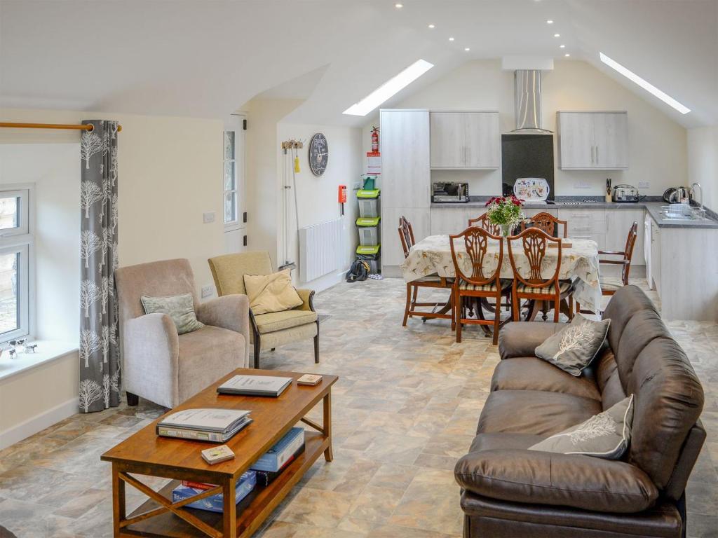 a living room with a couch and a table at Scrumpy Barn - Uk12014 in Luton