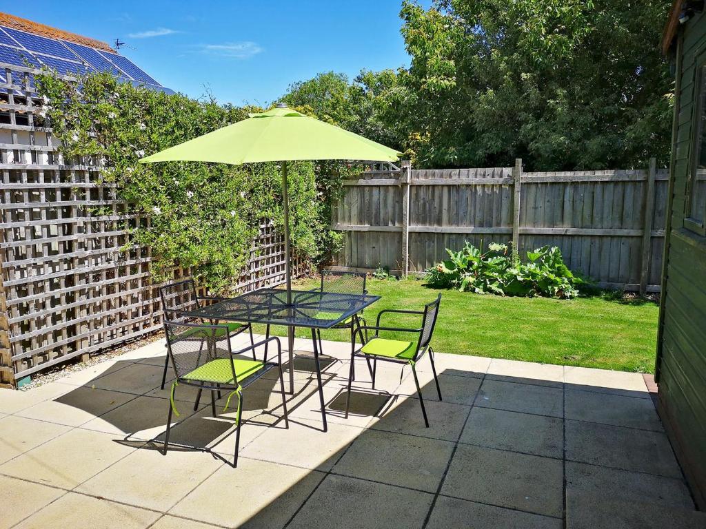 una mesa y sillas con una sombrilla en el patio en Isleport Lodge en Highbridge