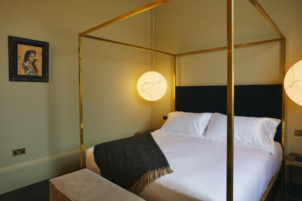 a bedroom with a bed with a four poster bed at The Vices York in York