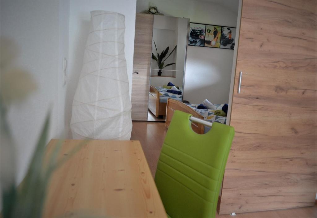 einen grünen Stuhl und einen Tisch in einem Zimmer in der Unterkunft Appartement Thermenzeit in Längenfeld