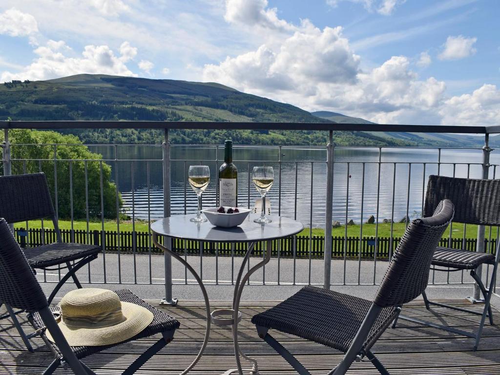 a table with two glasses of wine on a balcony at The Bothy in Stron-fearnan