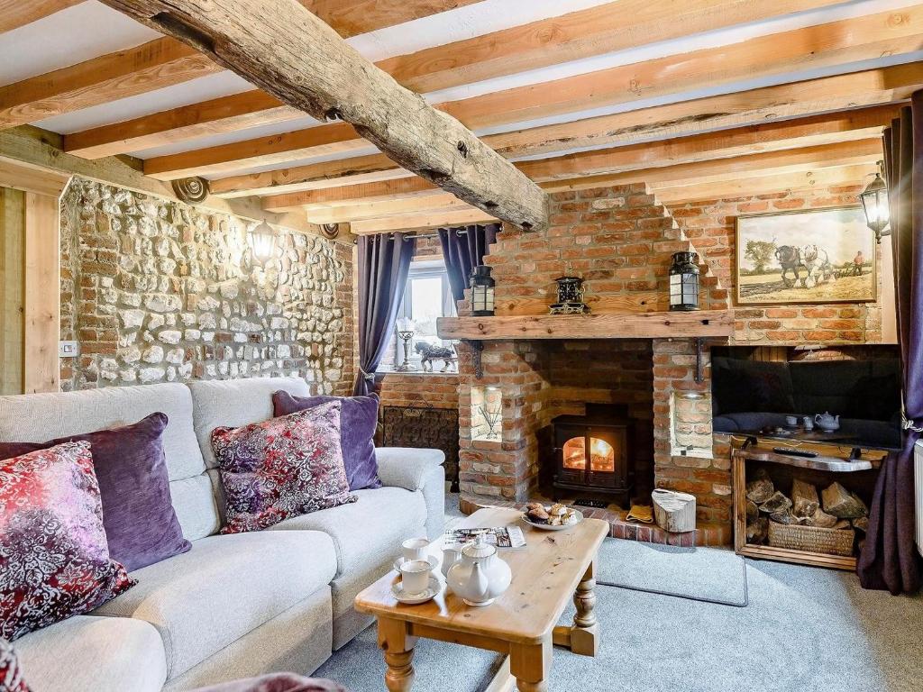a living room with a couch and a fireplace at Honey Pots in Foulden