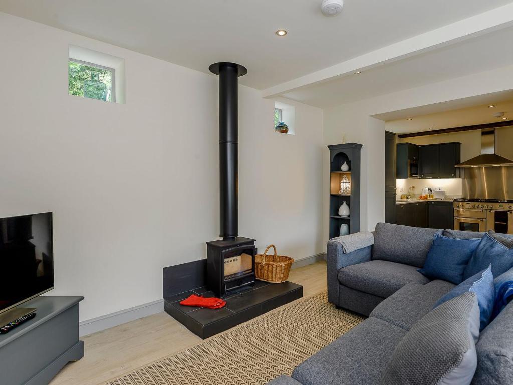 uma sala de estar com um sofá e um fogão em Bluestone Cottage em Welton le Wold