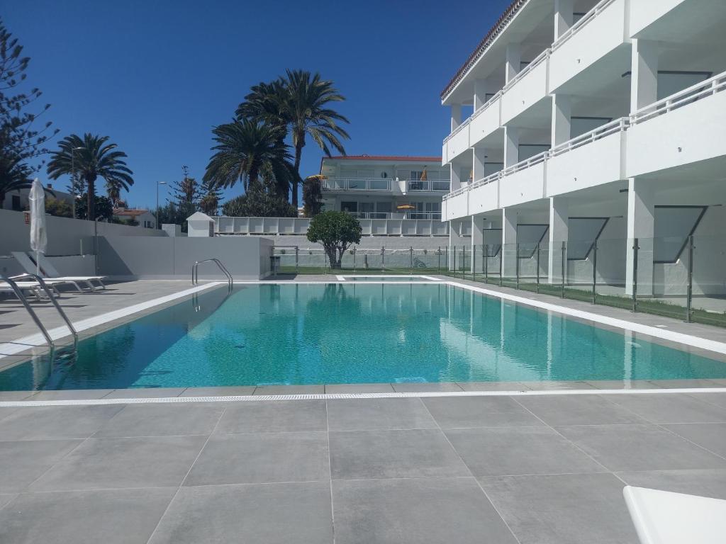 a swimming pool in front of a building at Apartamentos Marivista in Playa del Ingles