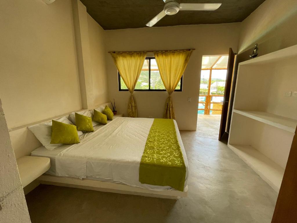 a bedroom with a large bed with yellow pillows at Casa Indica Colombia in Girardot