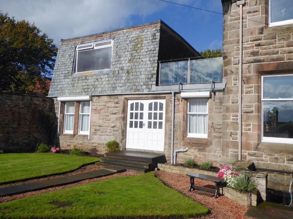 a brick house with a bench in front of it at Crail House in Crail