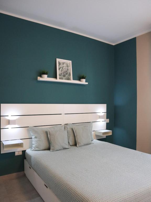 um quarto com uma cama grande e uma parede azul em Le Case di Sonia TRE GEMME GIADA Fucecchio em Fucecchio