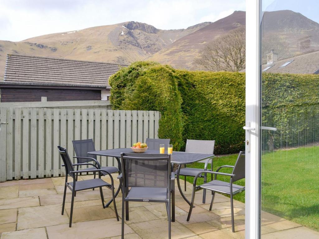 a table and chairs on a patio with mountains in the background at Cobble Rigg in Threlkeld