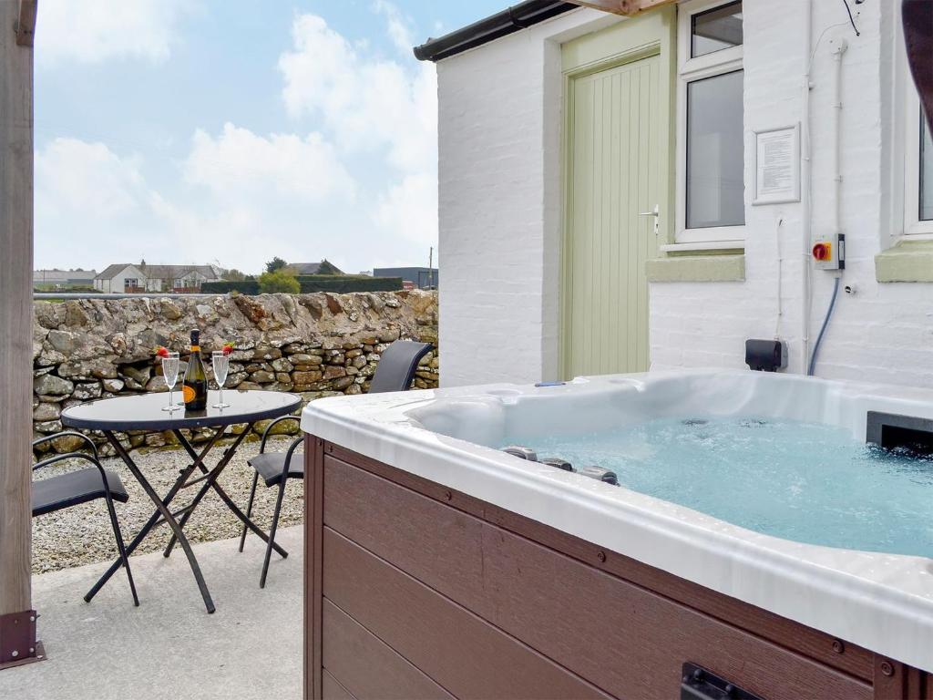 a hot tub on a patio with a table at Mid Bishopton Cottage - Uk10910 in Whithorn