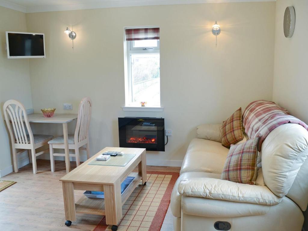a living room with a couch and a fireplace at Harland Cottage in Castletown