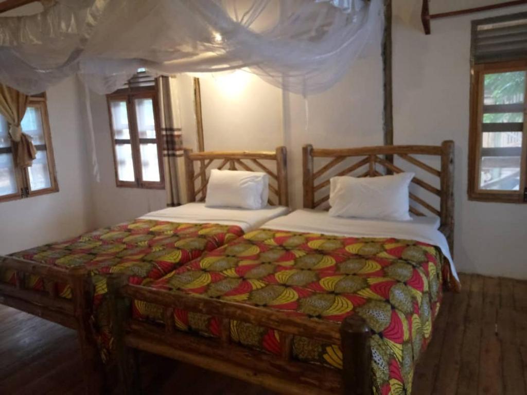 a bedroom with two beds in a room at Tembo Safari Lodge in Katunguru