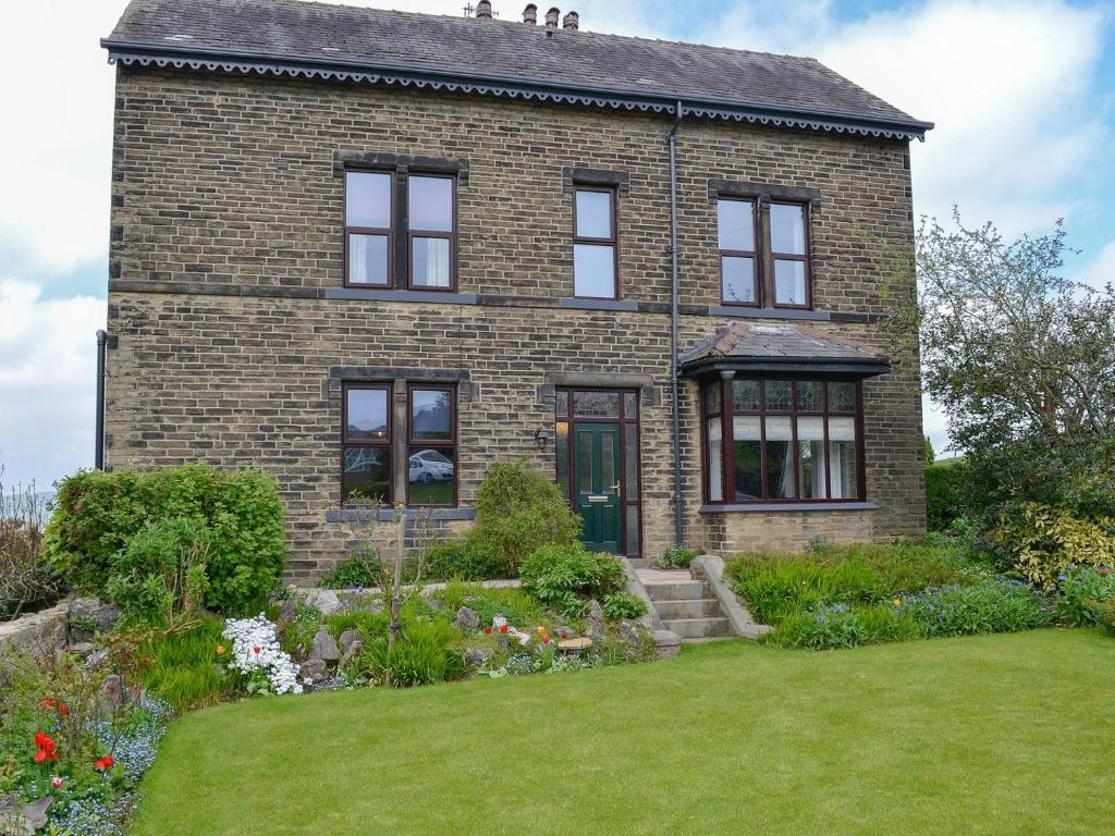 a brick house with a garden in front of it at Glenfield in Keighley
