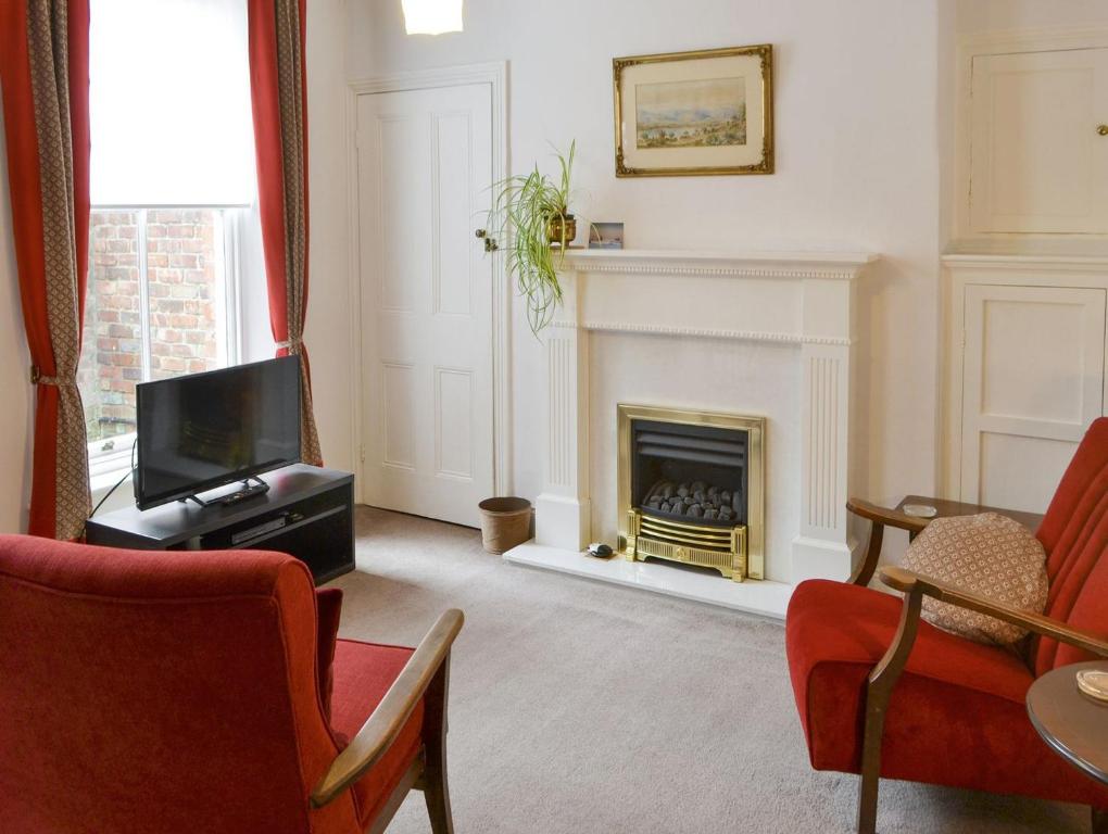 a living room with a tv and a fireplace at Drovers in Morpeth