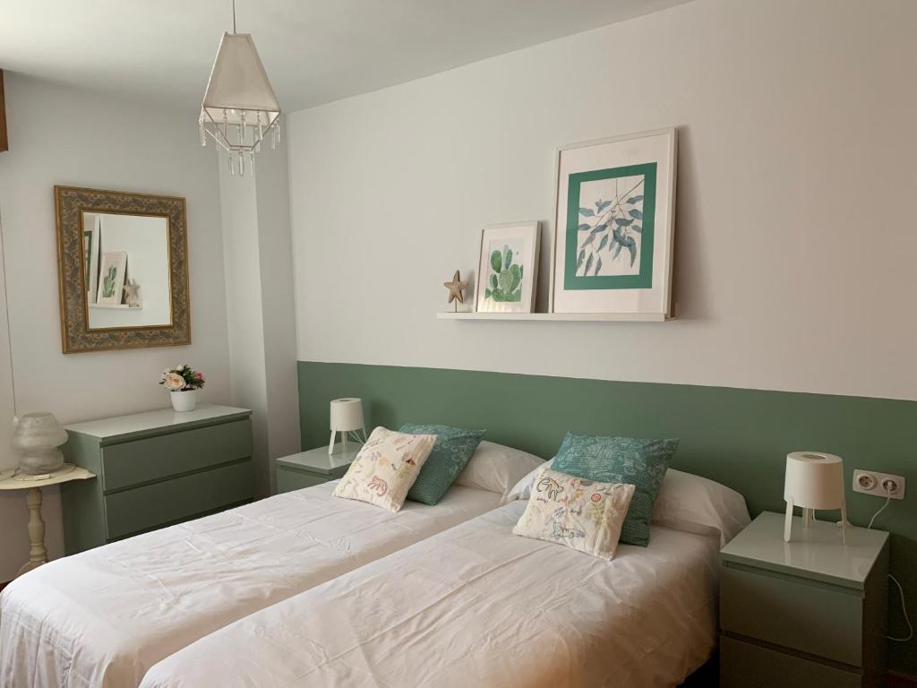 サラゴサにあるPrecioso piso recién reformado en Zaragozaのベッドルーム1室(ベッド2台、ナイトスタンド2台付)