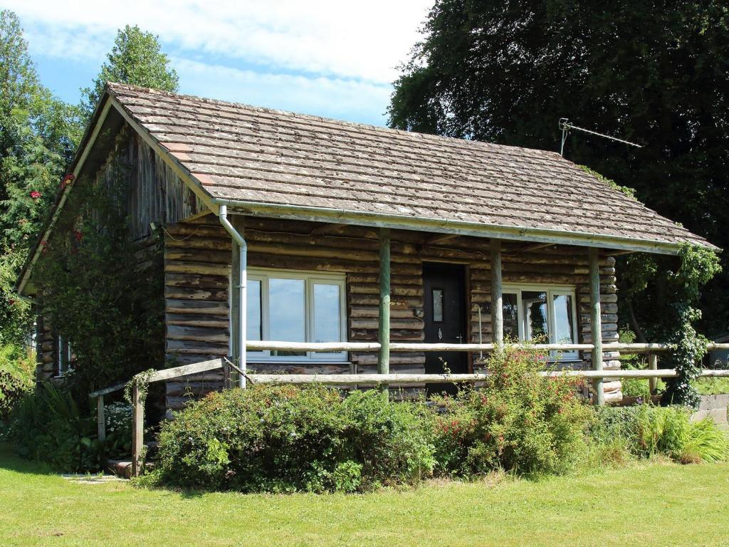 a log cabin with a porch and a window at The Garden House - Uk10987 in Llandogo