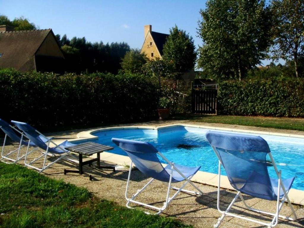 - un groupe de chaises assises à côté de la piscine dans l'établissement Gîte Asnières-sur-Vègre, 2 pièces, 2 personnes - FR-1-410-148, à Asnières-sur-Vègre