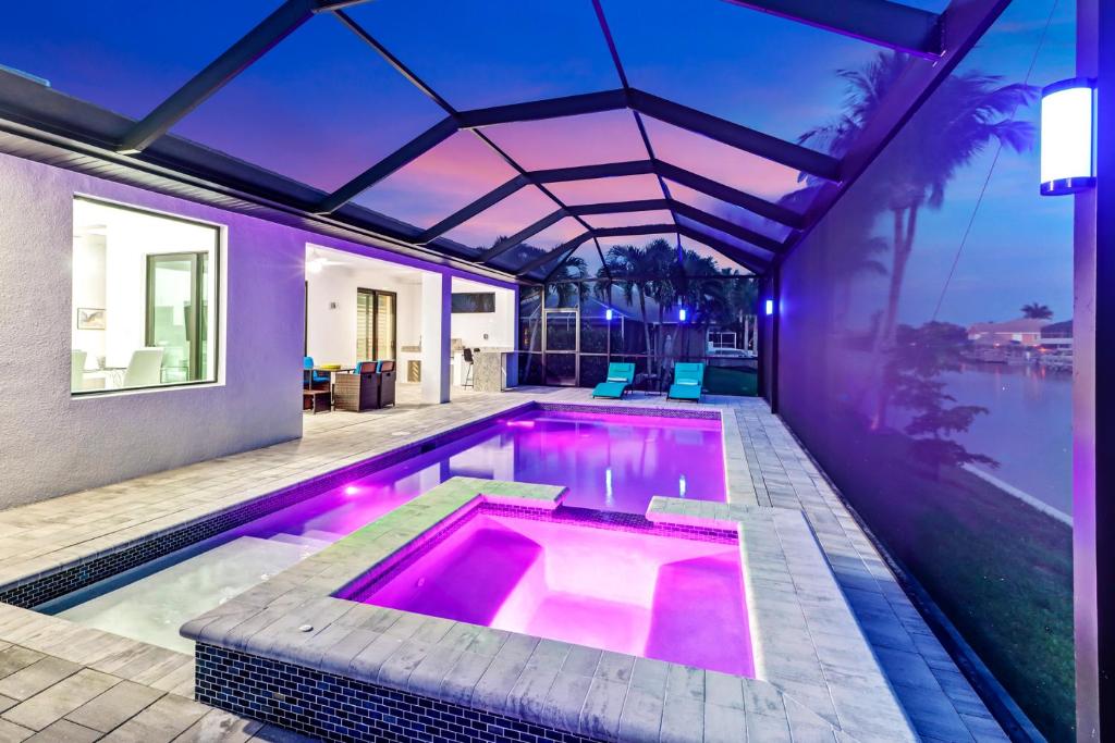 una piscina in una casa con illuminazione viola di The Twins Villa a Cape Coral