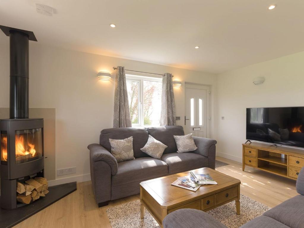 a living room with a couch and a fireplace at The Old Kennels in Tibberton