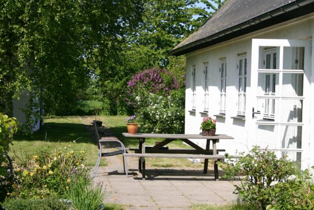 a picnic table in front of a white house at Holmehuset Bed & Breakfast in Kalundborg