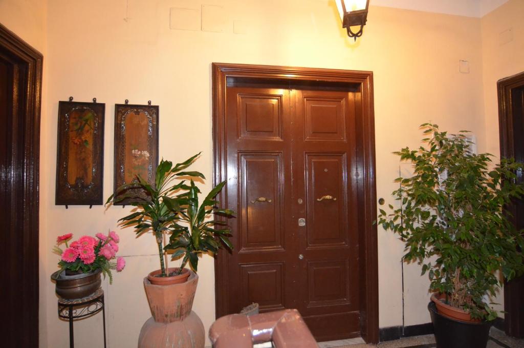 een kamer met een deur en enkele potplanten bij Meile House in Rome