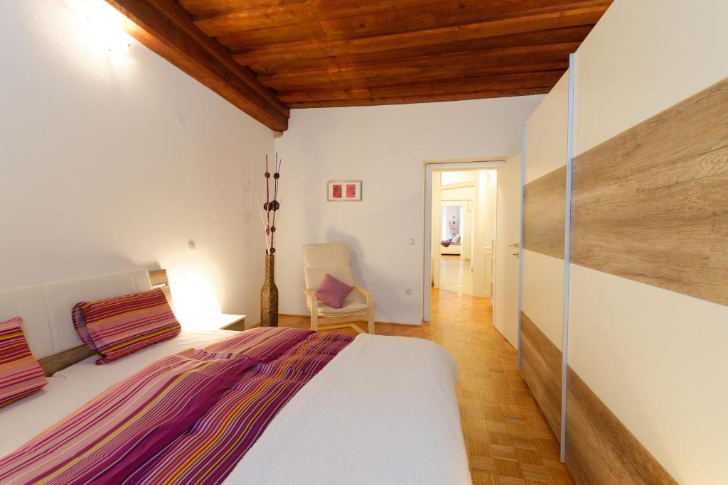 ein Schlafzimmer mit einem großen Bett und einer Holzdecke in der Unterkunft Ljubljana Center Apartments in Ljubljana