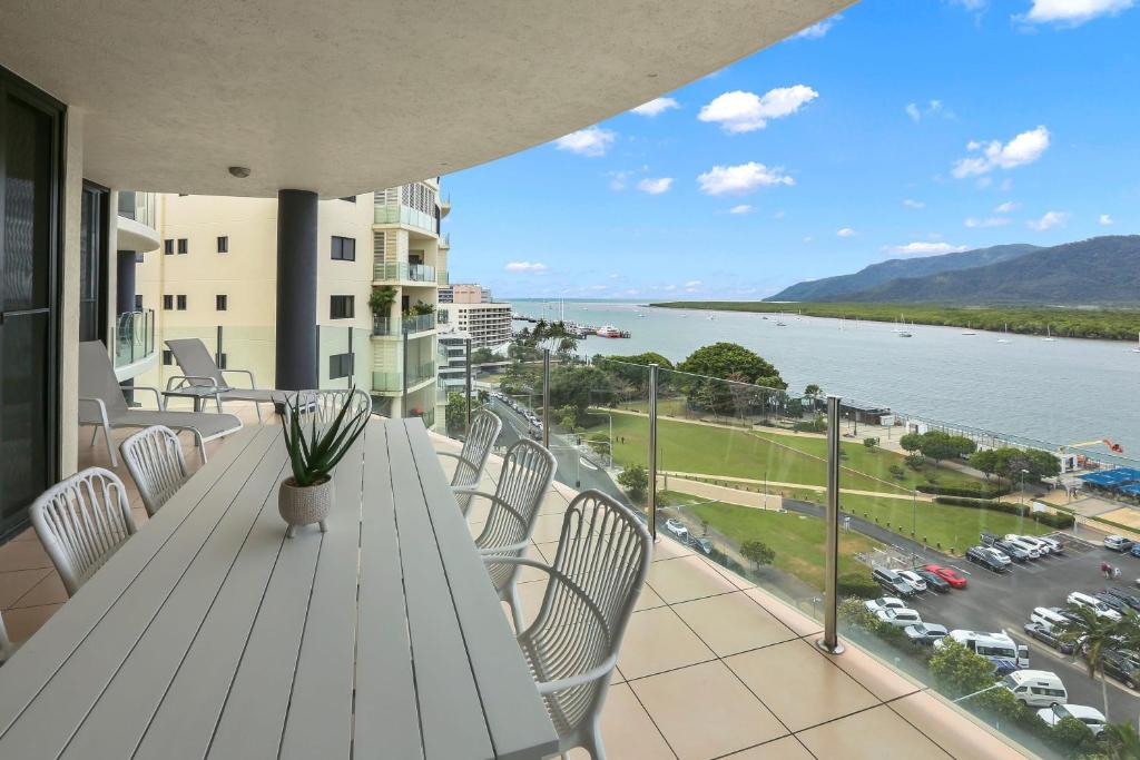 a balcony with a table and chairs and a view of the water at Seascape in Cairns