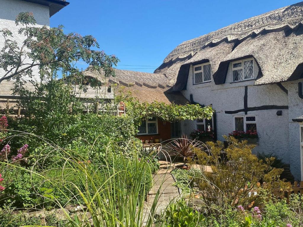 a thatched house with a garden in front of it at Primrose Cottage in Diseworth