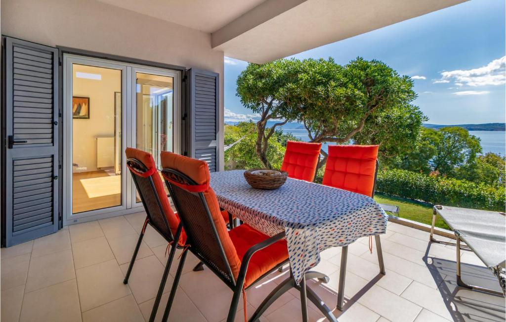 a table and chairs on a patio with a view of the ocean at 2 Bedroom Nice Apartment In Crikvenica in Crikvenica