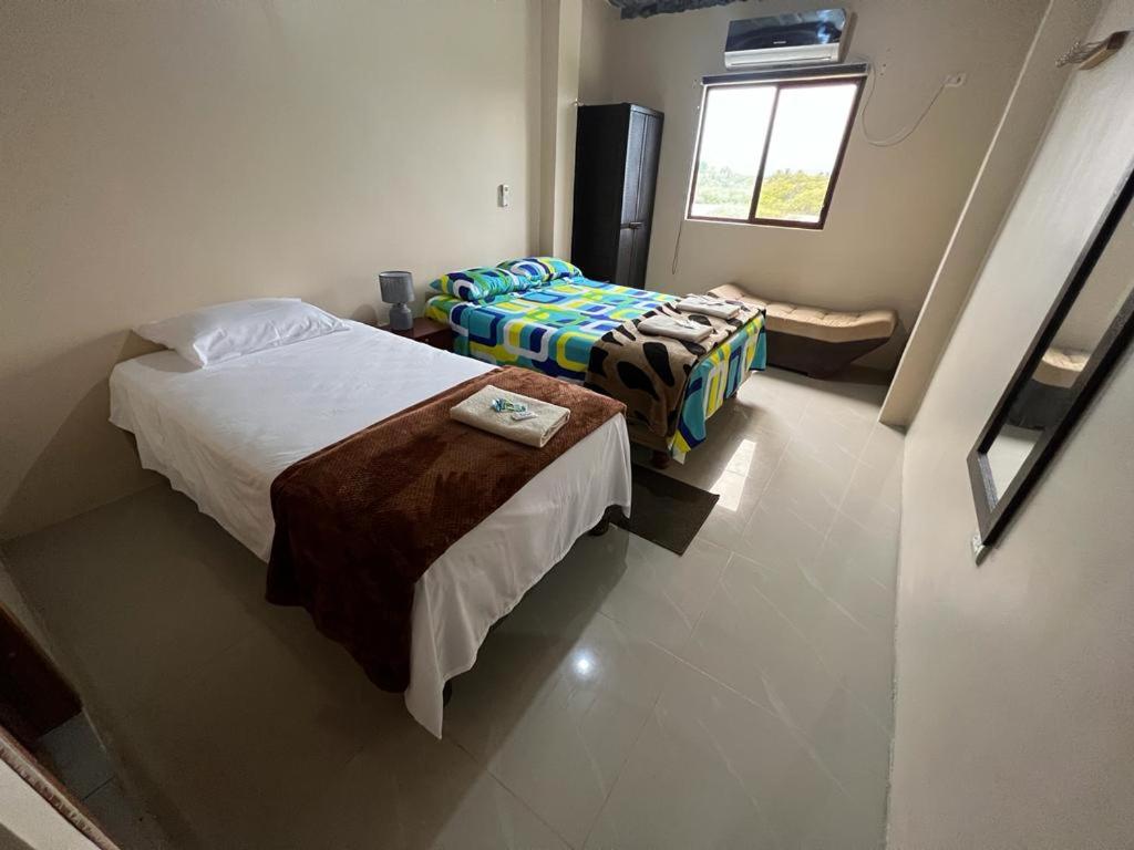 a hotel room with two beds and a window at House in Puerto Villamil