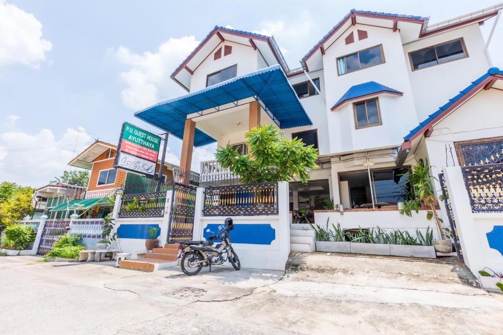 uma casa com uma moto estacionada em frente em Your Home AYUTTHAYA ยัวร์โฮม em Phra Nakhon Si Ayutthaya