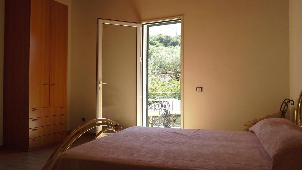 - une chambre avec un lit et une grande fenêtre dans l'établissement Oasi delle Madonie, à Scillato
