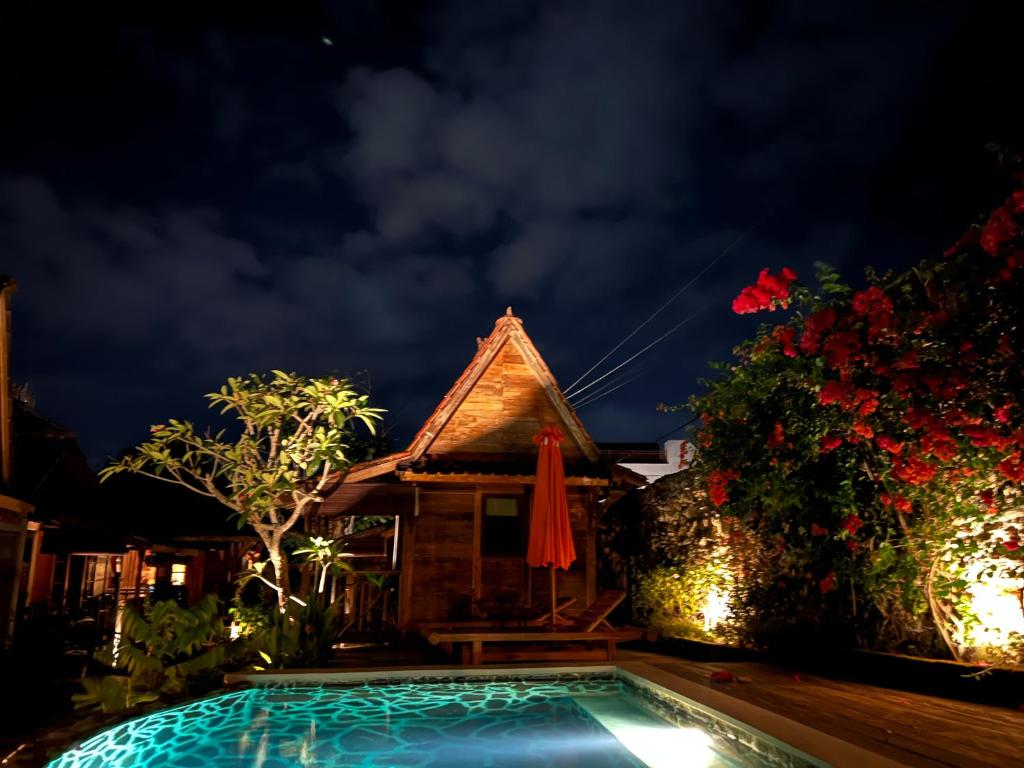 uma casa com piscina à noite em PINOKKIO B&B Restaurant em Ungasan