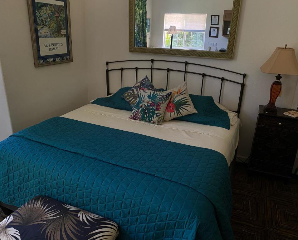 a bedroom with a bed with blue sheets and pillows at Heavenly Hana Paradise in Hana