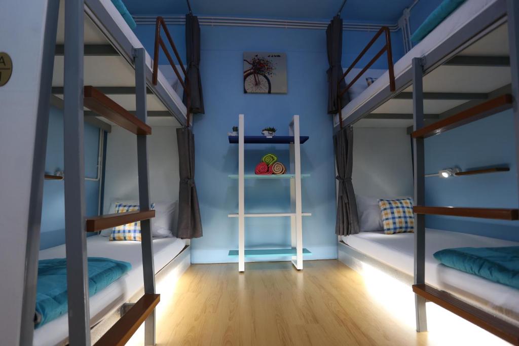 Zimmer mit 3 Etagenbetten und einem Regal in der Unterkunft iDeal Beds Hostel Ao Nang Beach in Ao Nang Beach