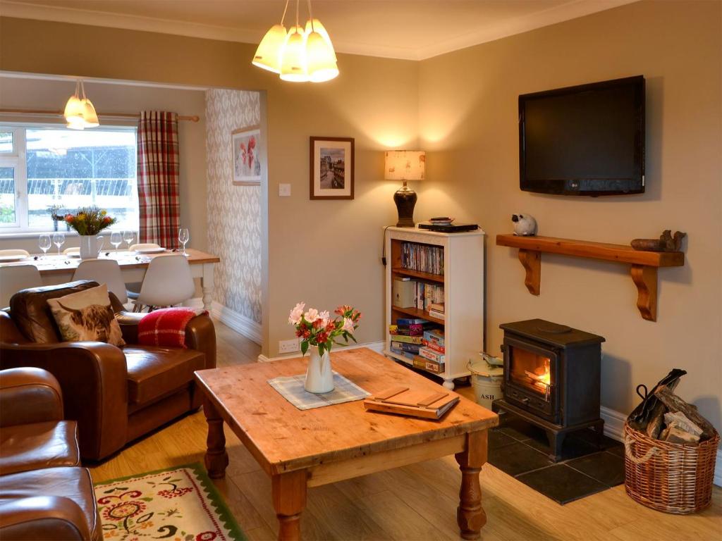 a living room with a table and a fireplace at Westfield Farm Cottage in Seaton Delaval