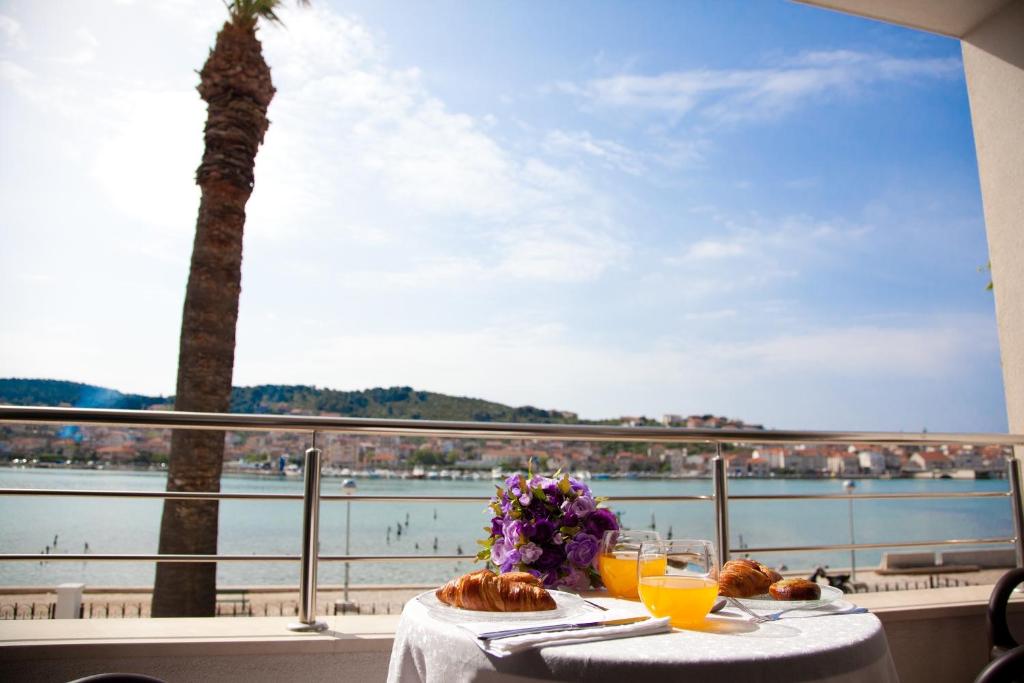 una mesa con comida y vistas al agua en Apartments Svjetlana, en Trogir