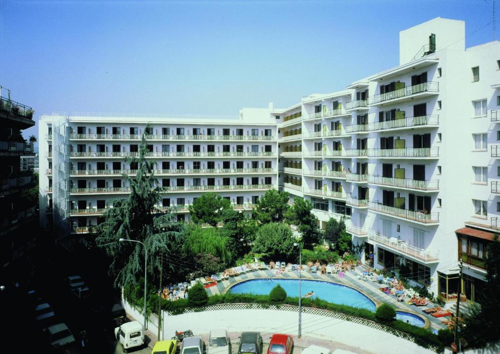 - un grand bâtiment avec une piscine en face dans l'établissement Clipper Affiliated by FERGUS, à Lloret de Mar