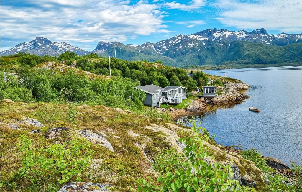 a house on the shore of a lake with mountains at Awesome Home In Laukvik With Kitchen in Laukvik