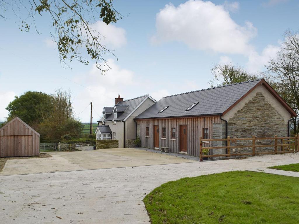 una casa con un granero y una valla en Bluebell Cottage - Uk12988, en Monington