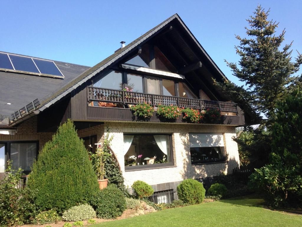 ein Haus mit einem Balkon mit Blumen im Fenster in der Unterkunft Ferienwohnung Will in Walkenried