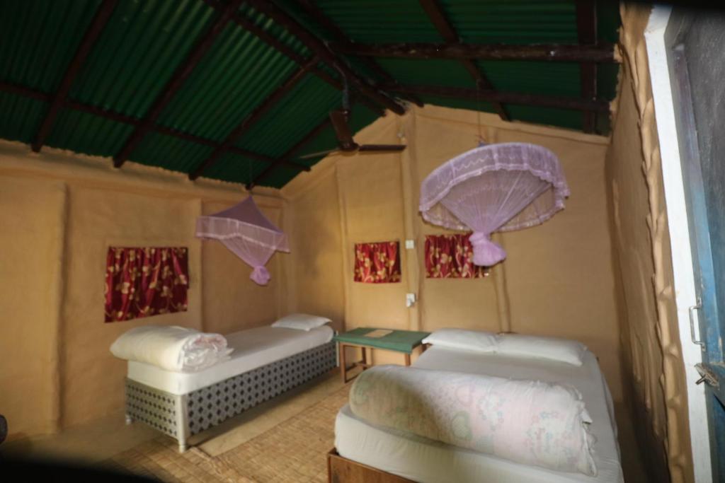 Een bed of bedden in een kamer bij Wild Planet Eco Retreat