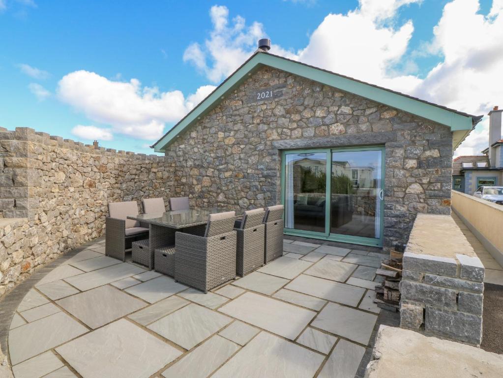 a patio with a table and chairs in front of a building at Y Bwthyn in Amlwch