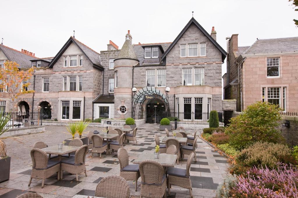 einen Blick nach außen auf ein Gebäude mit Tischen und Stühlen in der Unterkunft Malmaison Aberdeen in Aberdeen