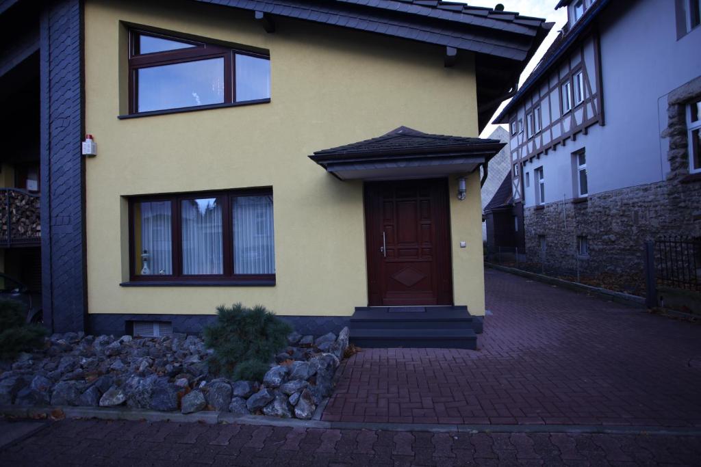 ein gelbes Haus mit brauner Tür auf einer Straße in der Unterkunft Ferienwohnung Hintze in Bad Harzburg