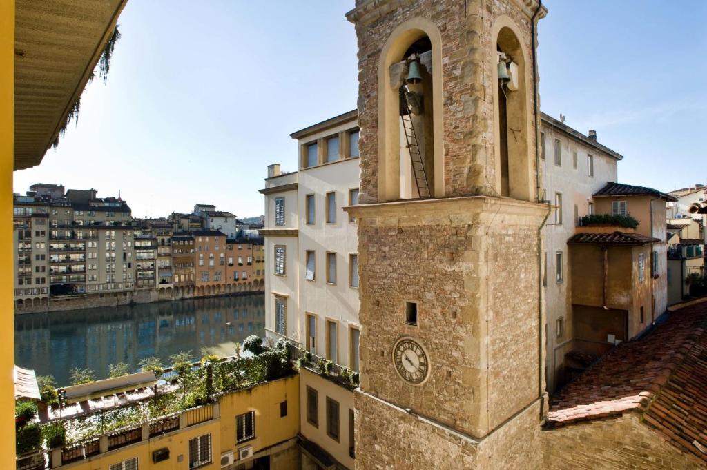ein Turm mit einer Uhr neben einem Gebäude in der Unterkunft Hotel Alessandra in Florenz