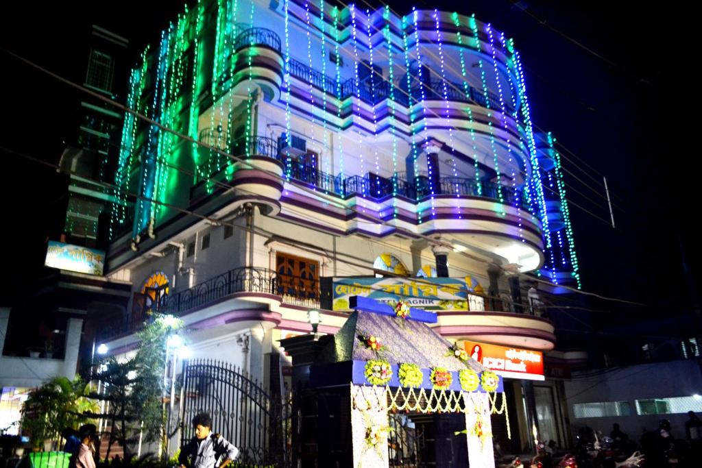 un edificio con luces de Navidad encendidas por la noche en hotel sagnik, en Murshidābād