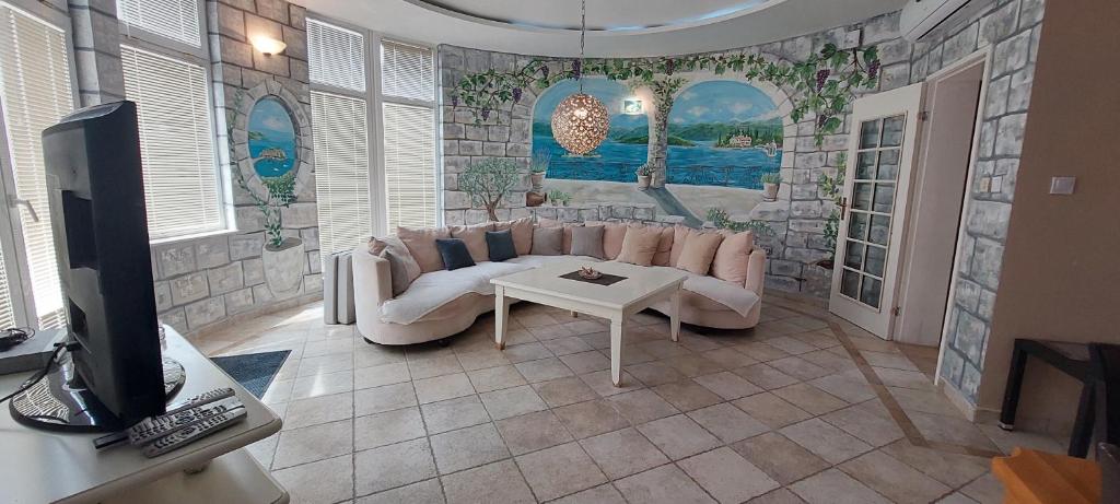 a living room with a couch and a tv at Spa Resort Luxury Apartments in Budva