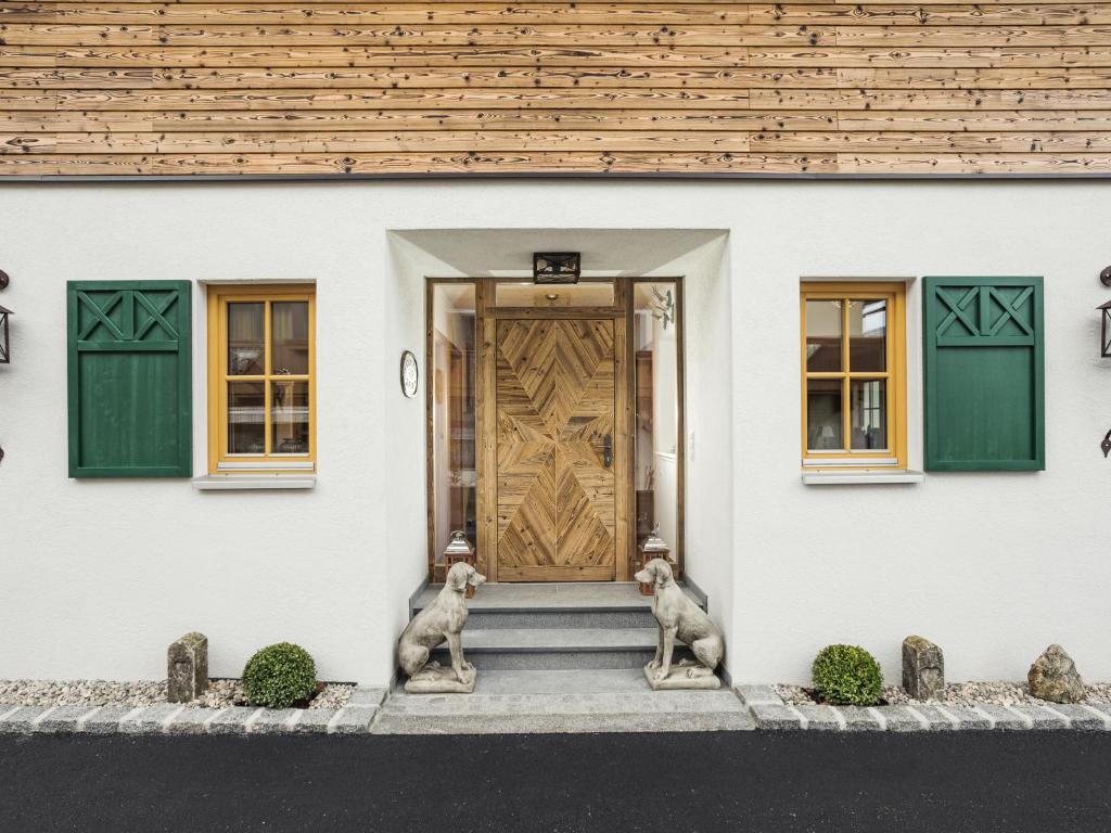 dos perros sentados frente a una casa con una puerta en Mountainspirit, en Mayrhofen