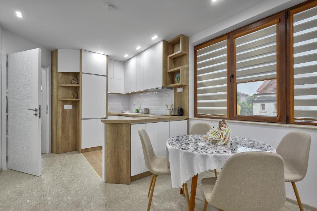 a kitchen with a table and chairs and a kitchen with white cabinets at Weiss Estate by EstateAutomata in Burgas City